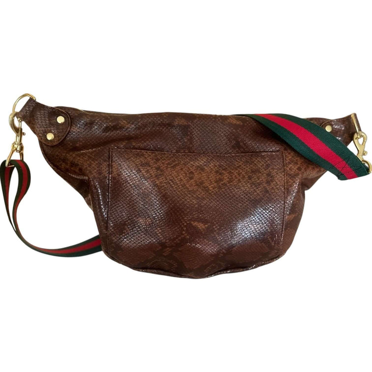 The Joan Brown Snake Crossbody bag in embossed leather, showcasing quality and beauty with gold hardware and striped strap.