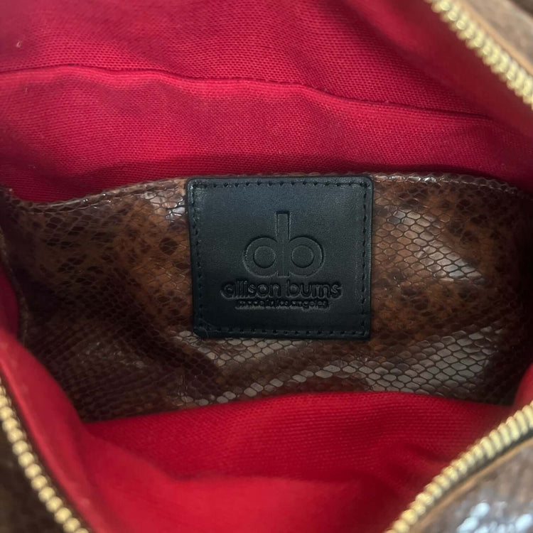 Interior view of The Joan Brown Snake Crossbody showcasing embossed leather and vibrant red lining.