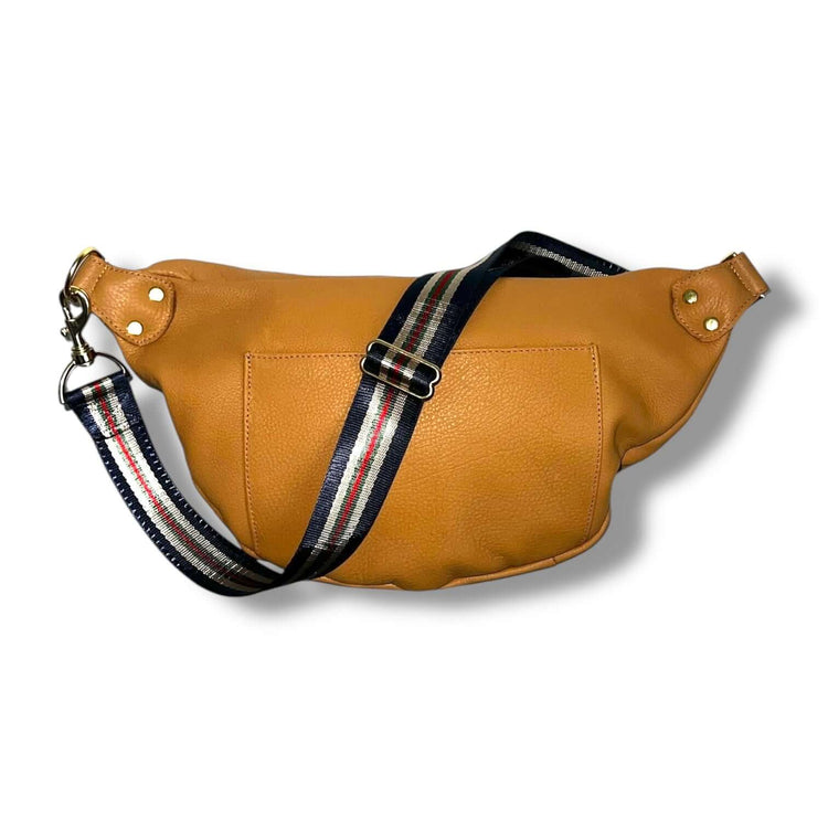 The Joan Saddle Bag in supple mustard leather with striped crossbody strap, combining quality and beauty for everyday joy.